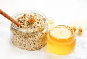 oats in a tub next to a jar of oat oil