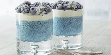blue chia seed pudding in glasses topped with berries
