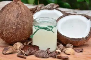 coconut oil in jar next to coconuts